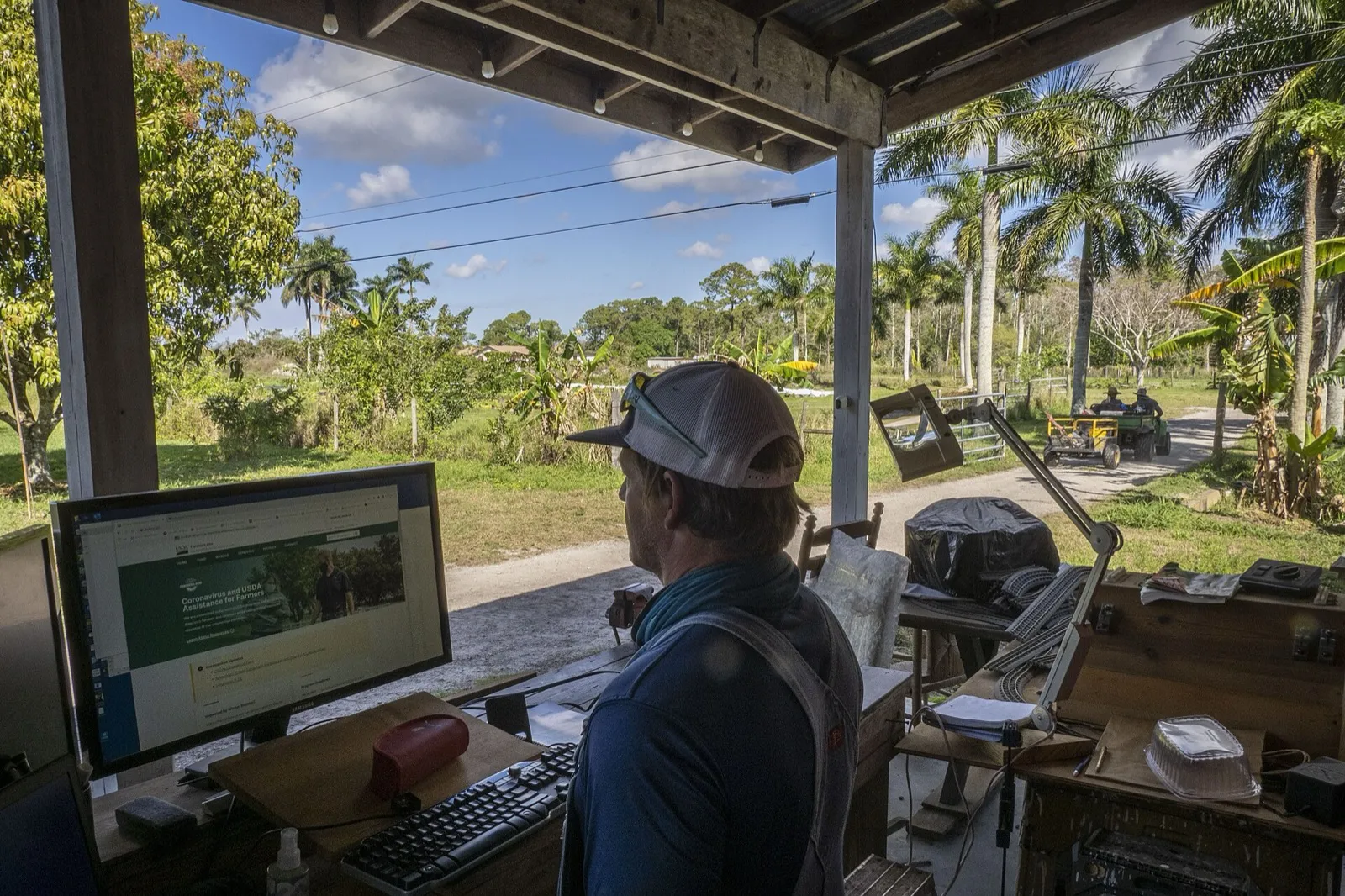A farmer at a computer in an open-sided farm office