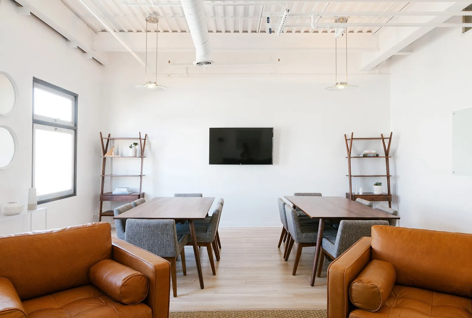 A bright meeting room with a long table and leather armchairs